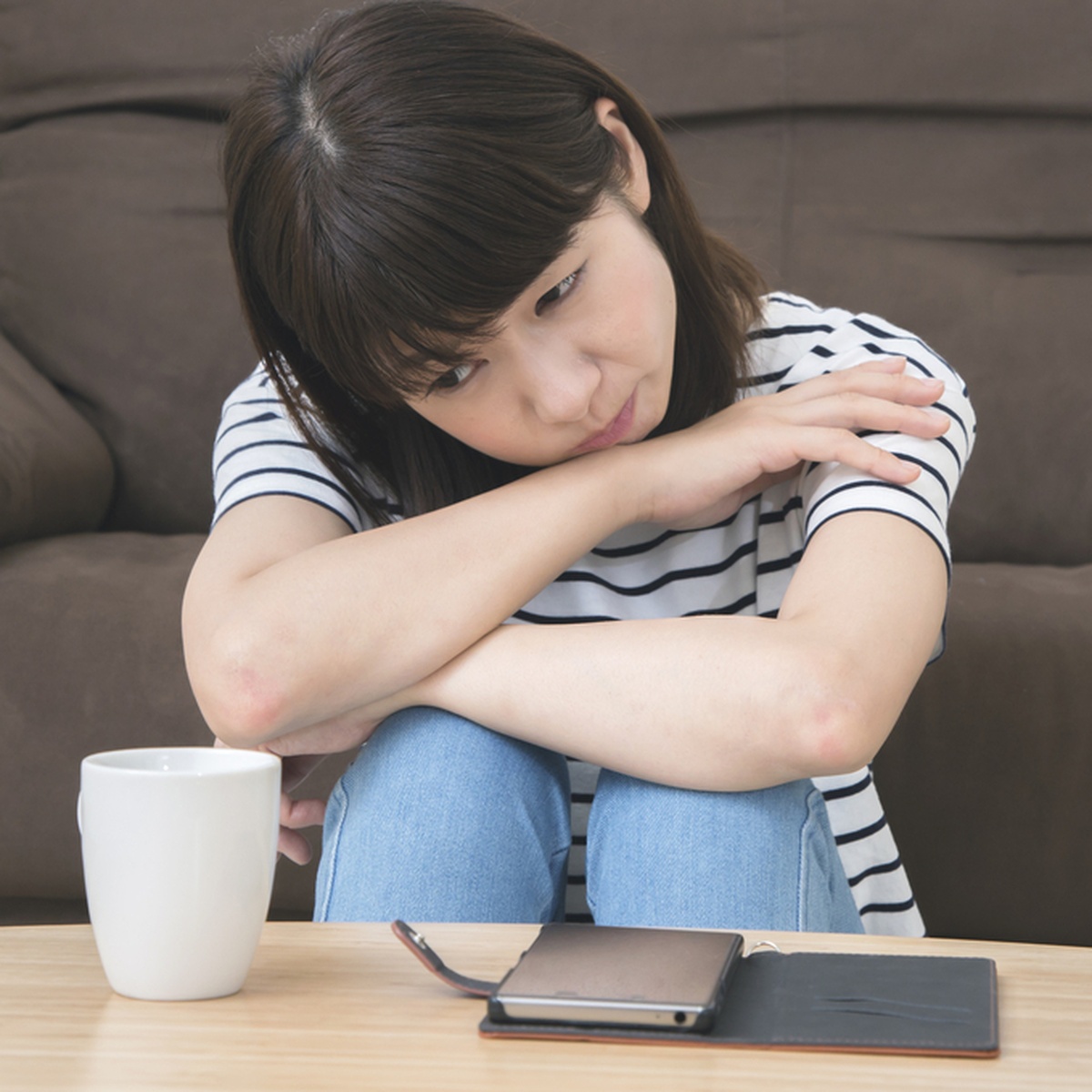 考えを整理しながらテーブルの前で座る人物